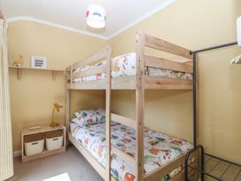A bedroom with bunk beds and storage baskets at Maenllwyd Borth-Y-Gest near Porthmadog