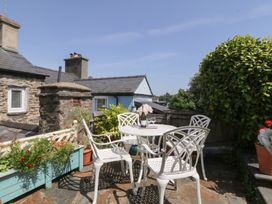 A garden with a table and chairs at Maenllwyd in Borth-Y-Gest near Porthmadog