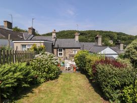 A garden with cottage view and patio furniture at Maenllwyd in Borth-Y-Gest near Porthmadog