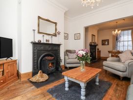 A living room with a fireplace and seating area at Charlotte House in Whitby