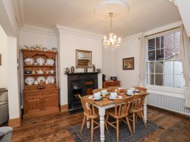 A dining room with a table set and a shelf at Charlotte House in Whitby