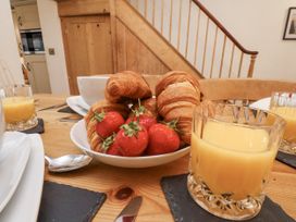 A dining table with croissants and strawberries in a bowl at Charlotte House in Whitby