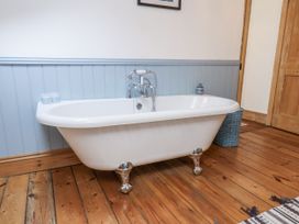 A bathtub with a faucet and decorative items at Charlotte House in Whitby