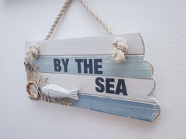 A decorative sign with the text 'BY THE SEA' at Charlotte House in Whitby