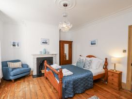 A bedroom with a bed and sofa at Charlotte House in Whitby