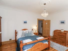 A bedroom with a bed and wooden furniture at Charlotte House in Whitby