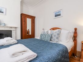 A bedroom with a bed and wardrobe at Charlotte House in Whitby