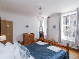 A bedroom with a bed and a dressing table at Charlotte House in Whitby