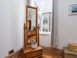 A bedroom with a mirror and a storage unit at Charlotte House in Whitby