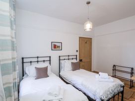 A bedroom with two single beds and a painting at Charlotte House in Whitby