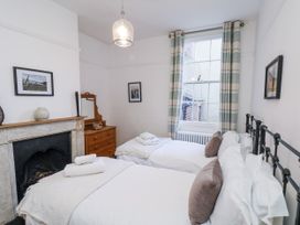 A bedroom with two beds and a mirror at Charlotte House in Whitby