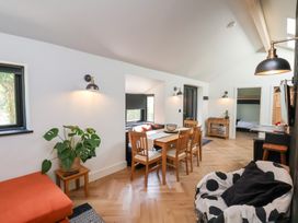 A dining area with wooden table and chairs next to a small sitting nook and an armchair in a room at The Haven in Cloughton near Burniston
