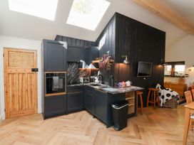A kitchen area with dark cabinets and marble countertops under skylights at The Haven in Cloughton near Burniston