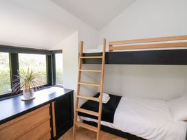 A bedroom with a wooden bunk bed and a window ledge with a plant at The Haven in Cloughton near Burniston