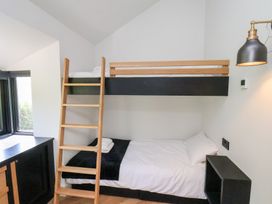 A small bedroom with a bunk bed wooden ladder and a wall lamp at The Haven in Cloughton near Burniston