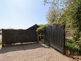 A fenced garden area with black wooden panels gravel ground and greenery at The Haven in Cloughton near Burniston