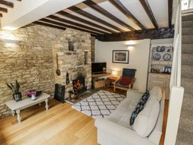 A living room with a fireplace and television at Dairy Cottage in Witney