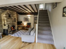 A living room with a sofa and television at Dairy Cottage in Witney