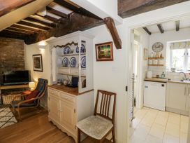 A living room with a television and armchair at Dairy Cottage in Witney