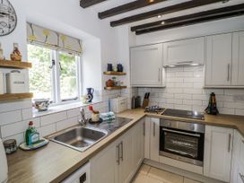 A kitchen with cabinets and a sink at Dairy Cottage in Witney