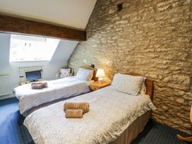 A bedroom with two beds and a television at Dairy Cottage in Witney