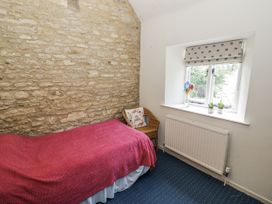 A bedroom with a single bed and window at Dairy Cottage in Witney