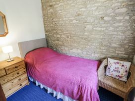 A bedroom with a bed and bedside lamp at Dairy Cottage in Witney