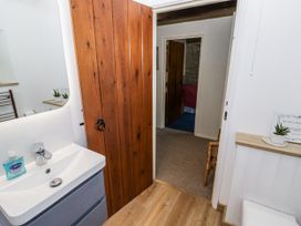 A bathroom with a sink and doorway at Dairy Cottage in Witney