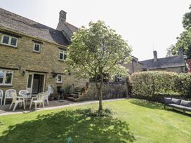 A garden with a table and chairs at Dairy Cottage Witney