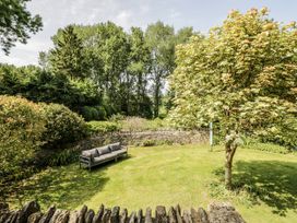 A garden with a sofa and trees at Dairy Cottage in Witney