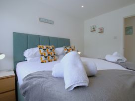 A bedroom with a bed with rolled towels on a blanket at 65 Channel View in Ilfracombe
