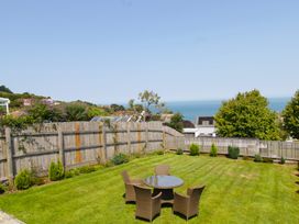 A garden with a table and chairs overlooking the ocean at 65 Channel View Ilfracombe