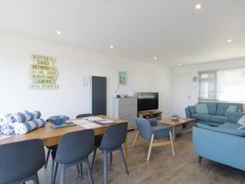 A living room with a dining area and a television at 65 Channel View Ilfracombe