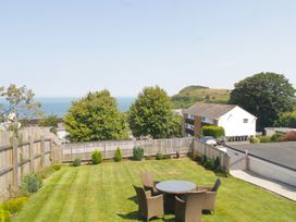 A garden with a table and chairs overlooking the ocean at 65 Channel View Ilfracombe