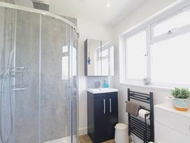 A bathroom with a shower, sink, and towel warmer at 65 Channel View Ilfracombe