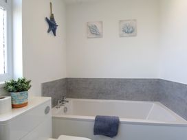 A bathroom with a bathtub and toilet at 65 Channel View in Ilfracombe
