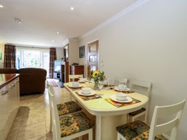 A dining room with a table set for meals at Birch Cottage in Brundall