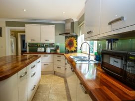 A kitchen with cabinets and a sink at Birch Cottage in Brundall