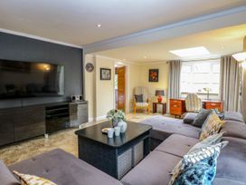 A living room with a sofa and television at Birch Cottage in Brundall
