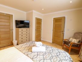 A bedroom with a bed and television at Birch Cottage in Brundall