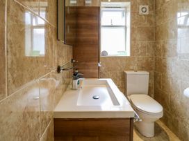 A bathroom with a wash basin and toilet at Birch Cottage in Brundall