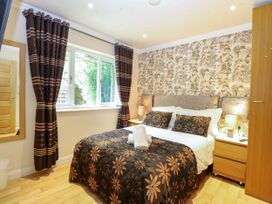 A bedroom with a bed and window at Birch Cottage in Brundall