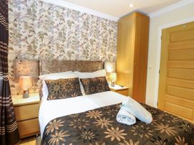 A bedroom with a bed and decorative pillows at Birch Cottage in Brundall