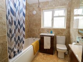 A bathroom with a bathtub, toilet, and sink at Birch Cottage in Brundall