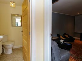 A bathroom with a toilet and a mirror at Birch Cottage in Brundall