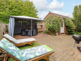 A garden with a patio and dining set at Birch Cottage in Brundall