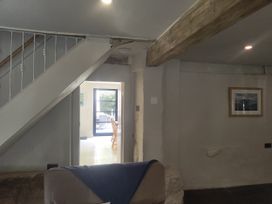 A living room with a staircase and a door to another room at Islwyn Llanuwchllyn near Bala