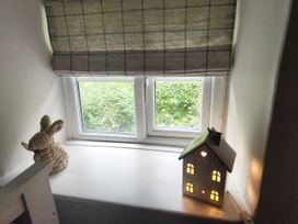 A window with a rabbit decoration and a light-up house decoration at Islwyn in Llanuwchllyn near Bala