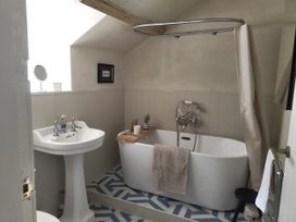 A bathroom with a bathtub and sink at Islwyn near Bala