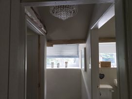 A hallway with a chandelier and a toilet at Islwyn Llanuwchllyn near Bala
